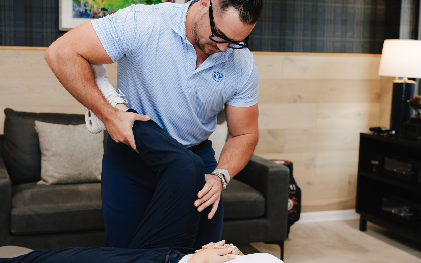 Chiropractor performing a low back adjustment on a patient lying on the treatment table