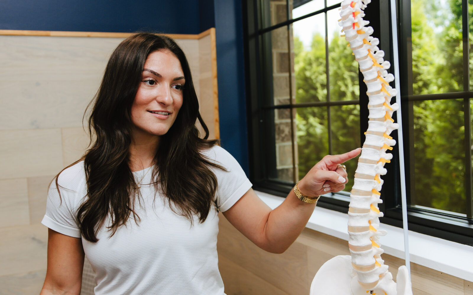 Forza Chiropractic team member holding a full spine model